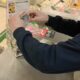 Человек кладет деньги в прозрачный ящик для сбора средств на лечение ребенка