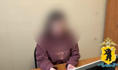 Пенсионерка с размытым лицом сидит за столом в помещении